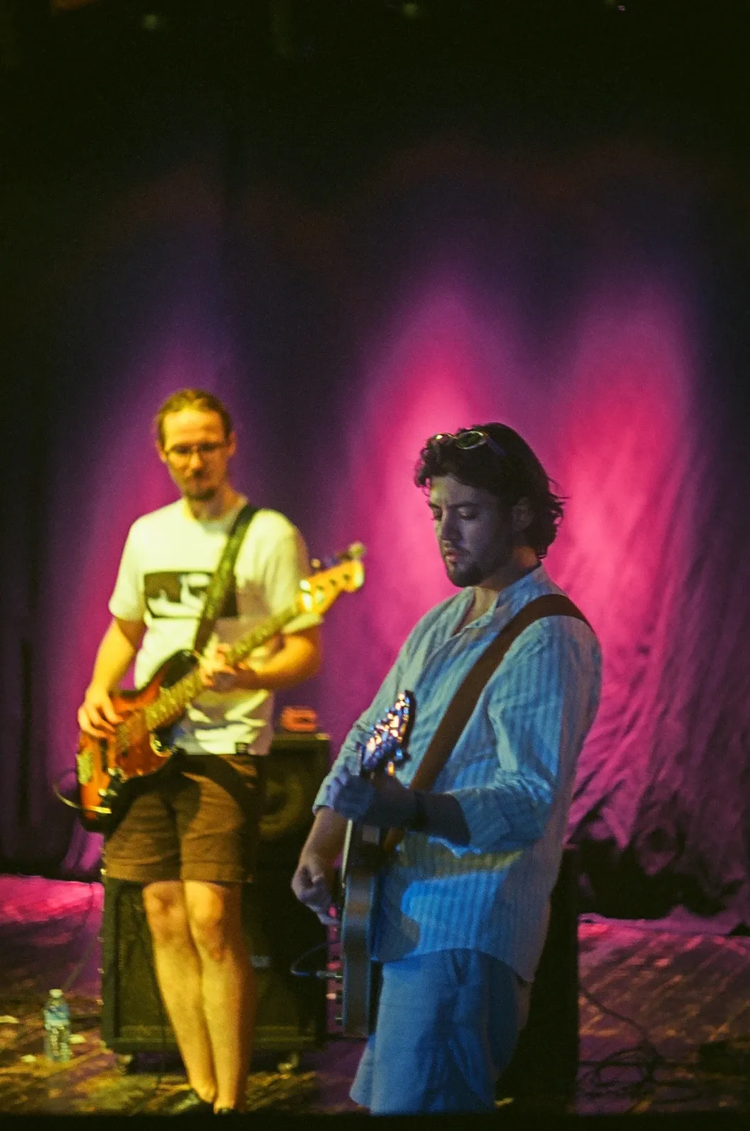 Guitarist and bassist of Hannetones bathed in pink stage light at Loď Tajemství